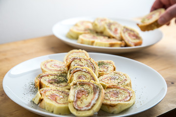 Mann nimmt Lachsrolle aus Omelette und Frischkäse mit Dill