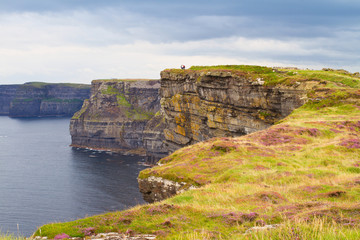 Fototapeta na wymiar Cliffs of Moher, west coast of Ireland, County Clare on wild Atlantic ocean. Photo of a beautiful scenic sea and sky landscape. View of ocean scenery, horizontal