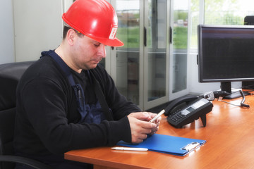 Electrician typing sms  in the power plant control center