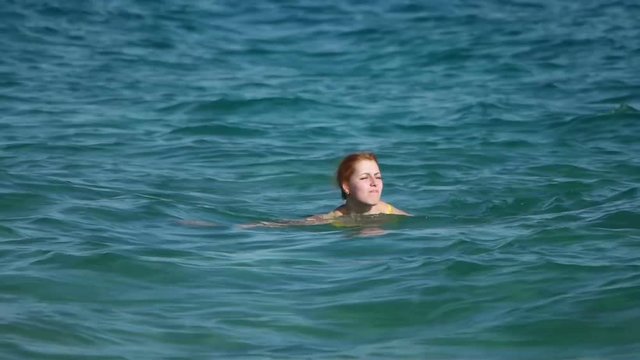 Girl swims in the sea, slow motion