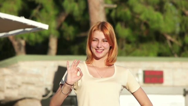girl shows gesture that everything is good, slow motion