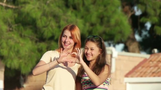 two girls show their hands heart, slow motion