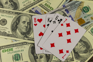 Playing cards on the American one hundred dollar bills background