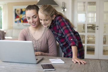 mother and daughter together on laptop