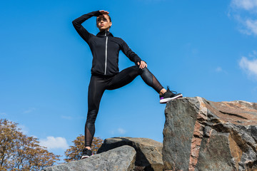 sportswoman standing on rocks