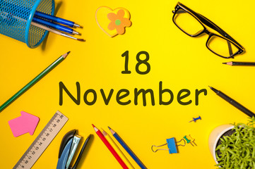 November 18th. Day 18 of last autumn month, calendar on yellow background with office supplies. Business theme