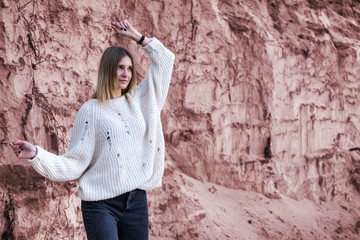 Toned portrait of a beautiful woman in a white sweater at the sand