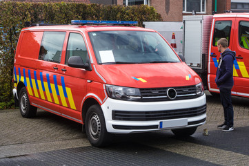 Red european fire departement car, three-quarter frontal view, with blue lights.