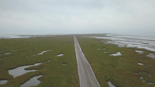 Aerial of Low tide path to the island Mand&oslash; in Denmark, only access by car &ndash; 4K