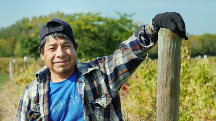 Portrait of an authentic Mexican farmer. Standing on the field, looking at the camera