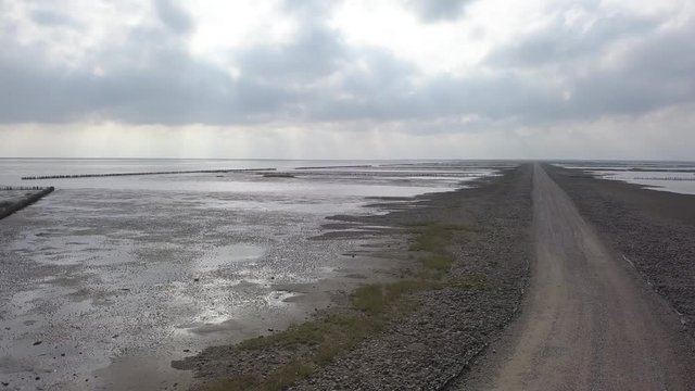 Aerial of Low tide path to the island Mand&oslash; in Denmark, only access by car &ndash; 4K