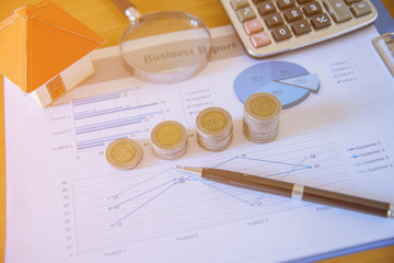 Saving money concept,graph, stacks of coins ,chart and pen ,copy space.selective focus,vintage color