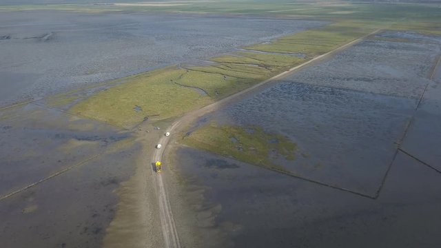 Aerial of Low tide path to the island Mand&oslash; in Denmark, only access by car &ndash; 4K