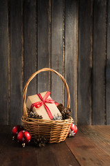 Christmas gif in craft paper with red ribbon in basket with copy space