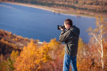 a man stands on top of a mountain and takes a picture of the landscape