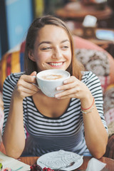 Young woman sitting indoor in urban cafe