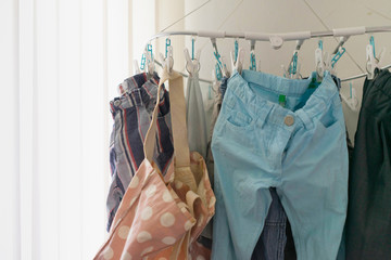 clothes line or hanging line of pants shorts pants bag near window with sunlight in daytime indoor home