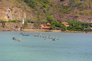 Offshore shrimp nets and stilted shacks for remote crew.