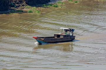 Fototapeta premium An old wooden boat float along the Soai Rap river shore