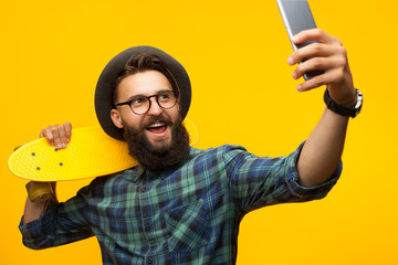 Cheerful hipster man taking selfie with longboard