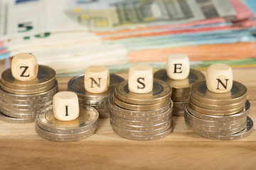 Euro Geldscheine und Münzen und das Wort Zinsen