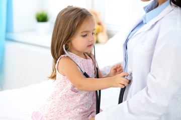 Happy little girl at  health exam at doctor office. Medicine and health care concept