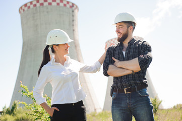 two workers wearing protective helmet works at electrical power station.