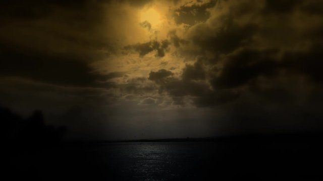 ''cloudy blue sky above a black surface of the sea''