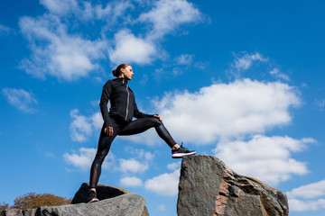 sporty woman on rocks