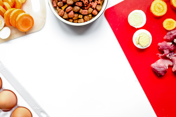 Dogfood, eggs, meat, carrot and courgette on table background to