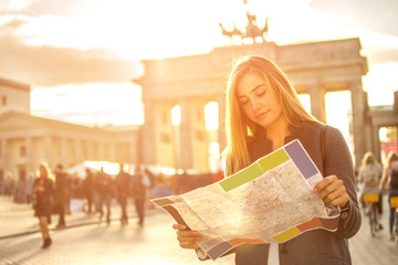 Young woman with map visiting the city of Berlin.
