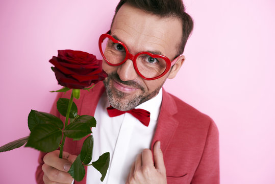 Man In Red Suit Holding A Rose