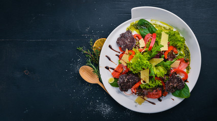 Beef Salad and Fresh Vegetables. On a wooden surface. Top view. Free space for your text.