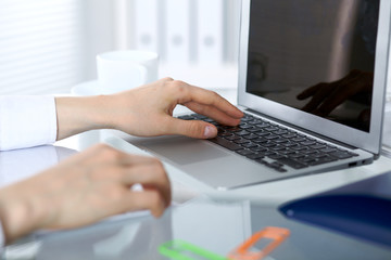 Close up of business woman hands typing on laptop computer