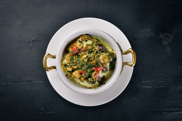 Baked vegetables with mushrooms and cheese. On a wooden surface. Top view. Free space for your text.