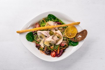 Salad of fresh vegetables and chicken fillet. On a wooden surface. Top view. Free space for your text.