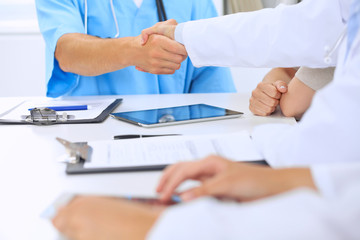 Fototapeta premium Doctors shaking hands to each other finishing up medical meeting