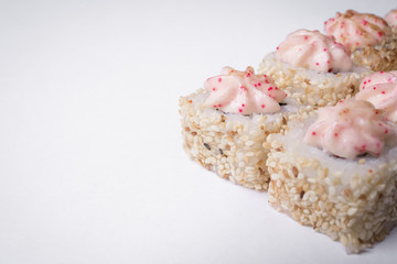Sushi roll in sesame seeds on a white background