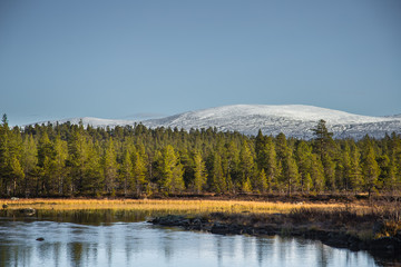 A beautiful lake landscape in Femundsmarka National Park in Norway. Lake with a distant mountains in background. Beautiful autumn scenery with vivid colors.