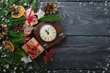 Clock. Christmas wooden background. New Year's holiday. Christmas motive. On a wooden surface. Top view. Free space for your text.