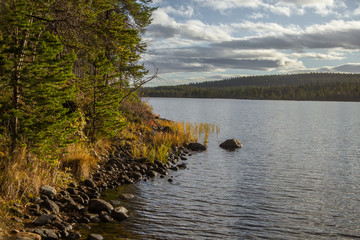 A beautiful lake landscape in Femundsmarka National Park in Norway. Lake with a distant mountains in background. Beautiful autumn scenery with vivid colors.