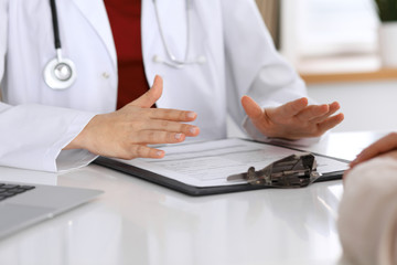 Close up of a doctor and patient hands while discussing medical records after health  examination