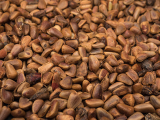 Natural looking pine nuts as food background. Selective focus.