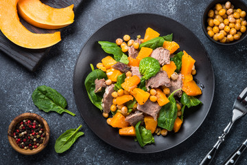 Warm salad with pumpkin, baked beef, spinach and chickpeas.