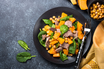 Warm salad with pumpkin, baked beef, spinach and chickpeas.