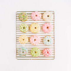 Colorful donuts on baking tray. Flat lay, top view minimal pattern.