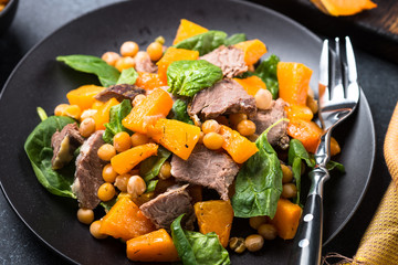 Warm salad with pumpkin, baked beef, spinach and chickpeas.