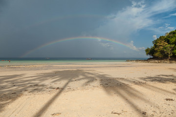 Colorful rainbow over a Tropical beach of Andaman Sea, Thailand.