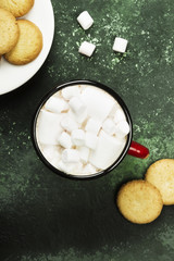 Cup of hot chocolate and cookies for Christmas on a green background. Top view