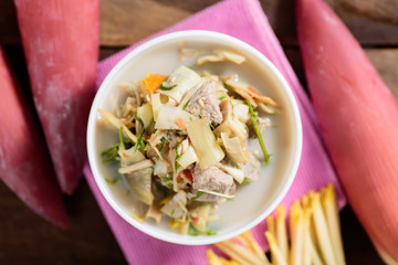 Thai food (Kaeng Hua Plee), spicy banana flower soup with pork in a bowl. Top view of food